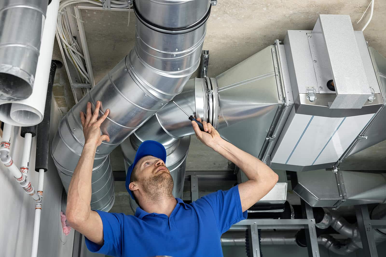 HVAC technician inspecting and repairing air ducts in Olivehurst