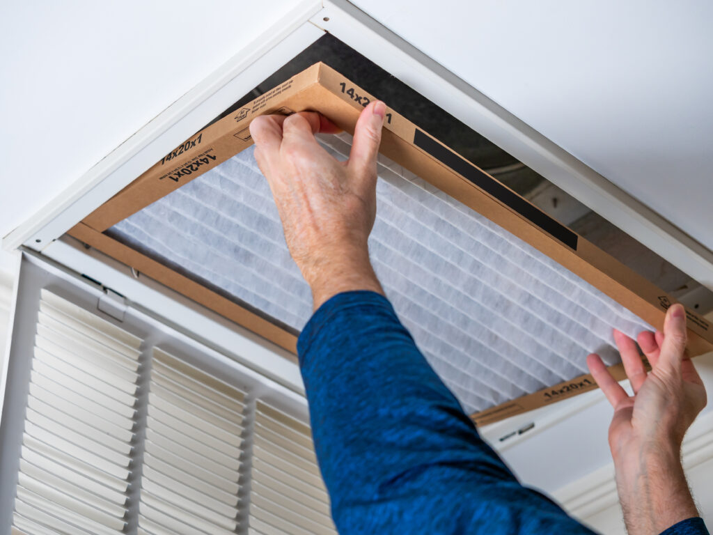 HVAC technician replacing a home air filter in Olivehurst