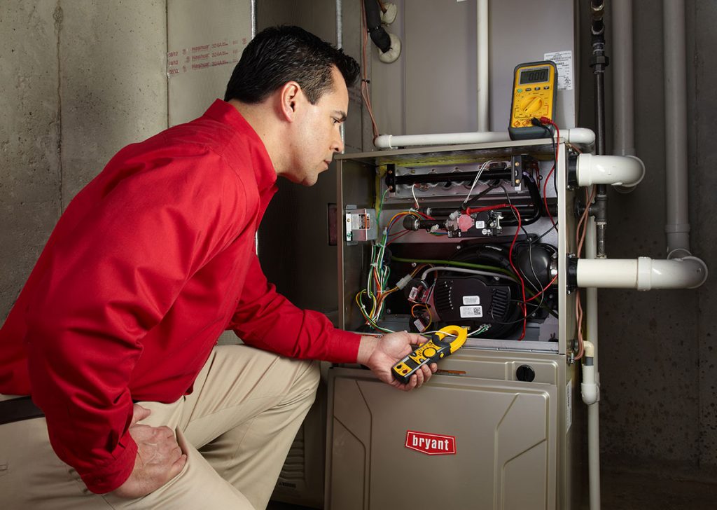 Heating technician diagnosing a furnace repair in Olivehurst