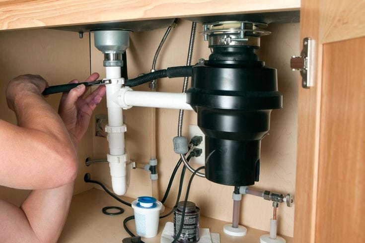 Plumber repairing a garbage disposal in Olivehurst