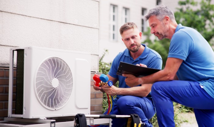 HVAC technicians installing an outdoor air conditioning unit in Olivehurst