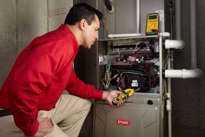 Heating technician diagnosing a furnace repair in Olivehurst