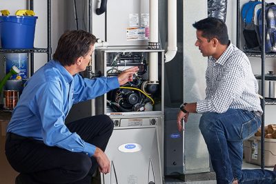 Technician evaluating a furnace for repair or replacement in Olivehurst