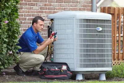 HVAC technician inspecting an outdoor AC unit in Olivehurst